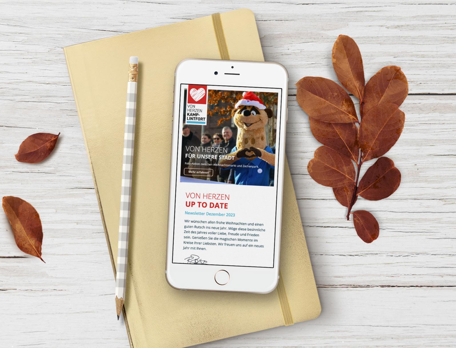 Ein Smartphone auf dem der Newsletter zu sehen ist liegt auf einem Schreibtisch